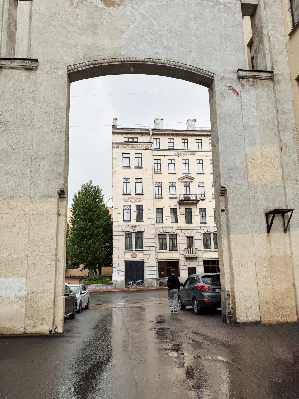Вид сквозь арку-подворотню на фасад доходного дома в стиле модерн, Петербург